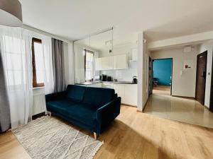 a living room with a blue couch and a kitchen at Sopot Marina Beach Elegance in Sopot