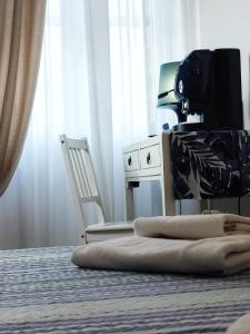 sypialnia z łóżkiem z krzesłem i biurkiem w obiekcie Al Teatro Suites w mieście Foggia