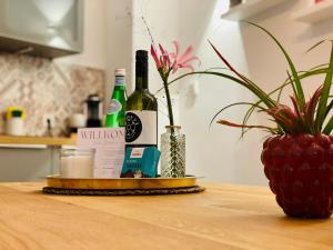 a table with two bottles of wine and a plant at Der Vitihof Schanzenblick Suite in Osnabrück