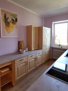 una cocina con armarios de madera y una ventana en Unsere neue Ferienwohnung Hereinspaziert 