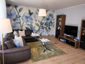 sala de estar con sofá y pared de flores en Unsere neue Ferienwohnung Hereinspaziert 
