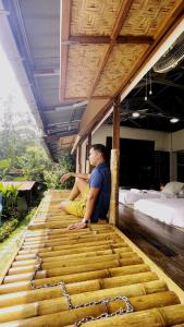 a person sitting on top of a wooden floor at Tirtha Quddus Farmstay in Bentong