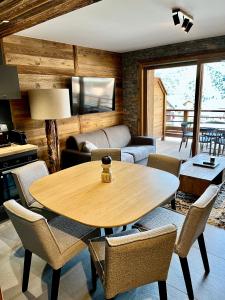 sala de estar con mesa de madera y sillas en Appartement au pied des pistes - Olvera 403, en Valmeinier
