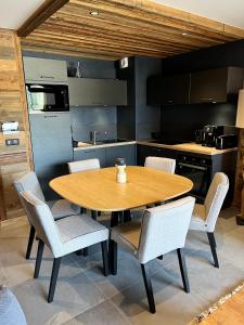 una mesa de madera y sillas en la cocina en Appartement au pied des pistes - Olvera 403, en Valmeinier