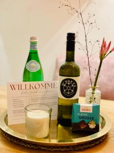 a plate with two bottles of wine and a glass at Der Vitihof Pastoren Suite in Osnabrück +4 photos