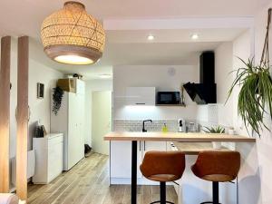 a kitchen with a counter and two bar stools at Mon cocon nature : tout équipé - proche frontière in Maîche