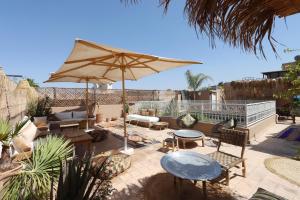 a patio with a table and an umbrella at Riad NaaNaa Bed & Breakfast in Marrakech