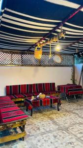 Taiyiba的住宿－Petra Glamour Hostel，一间设有红色长椅和蓝色及白色天花板的客房
