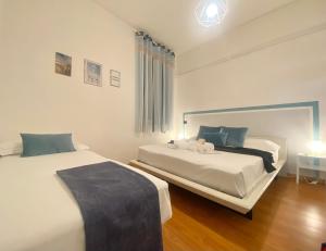 ein Schlafzimmer mit 2 Betten und einem Tisch mit einer Lampe in der Unterkunft MAZZINI 12- Appartamento centrale con posto auto privato-wifi-aria condizionata in Rapallo