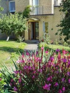 un jardín con flores rosas frente a una casa en Pas Vidą en Nida