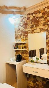 La salle de bains est pourvue d'un miroir et d'un mur en pierre. dans l'établissement Petra Glamour Hostel, à Taiyiba