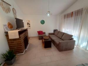 ein Wohnzimmer mit Sofa und Fernseher in der Unterkunft La Casa de Belén in Villa General Belgrano