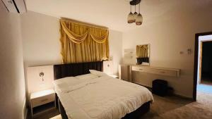 a bedroom with a white bed and a window at Petra Glamour Hostel in Taiyiba