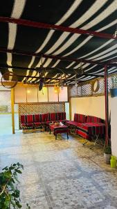 une chambre avec des chaises rouges et une table dans un bâtiment dans l'établissement Petra Glamour Hostel, à Taiyiba