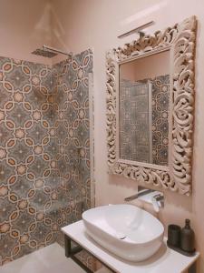 a bathroom with a sink and a mirror and a shower at Maccus Suite in Naples