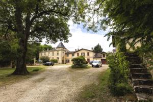 una casa grande con coches estacionados frente a ella en Chateau La Croix De Millorit, 