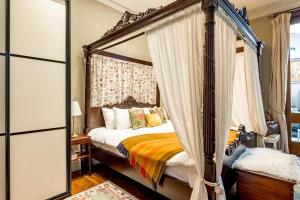una camera con letto a baldacchino e specchio di The Regency Studio at 82 Cathedral a Cardiff