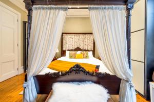 a bedroom with a canopy bed with curtains at The Regency Studio at 82 Cathedral in Cardiff