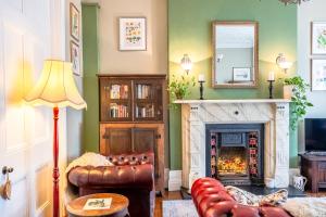 a living room with a fireplace and a mirror at The Regency Studio at 82 Cathedral in Cardiff