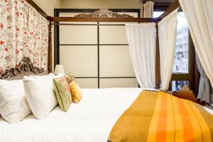 una camera da letto con un letto bianco con baldacchino di The Regency Studio at 82 Cathedral a Cardiff