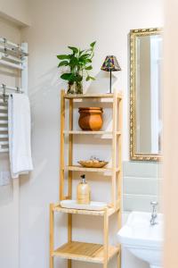 a bathroom with a bamboo shelf with a plant on it at The Regency Studio at 82 Cathedral in Cardiff