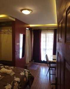 a bedroom with a bed and a desk and a window at STERLEON HOTEL RIVERSIDE in Nairobi