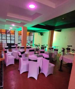 a room with white tables and chairs and green lights at STERLEON HOTEL RIVERSIDE in Nairobi