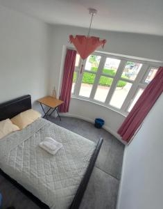 een slaapkamer met een bed en een groot raam bij Morgan Ease in Manchester