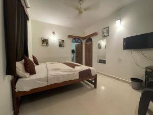 a bedroom with a bed and a flat screen tv at Baga View Inn in Baga