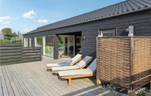 una casa negra con un montón de sillas en una cubierta en 4 Bedroom Stunning Home In Haderslev en Haderslev