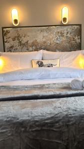uma cama grande com lençóis brancos e almofadas em Shanroe Accommodation em Mullaghbane
