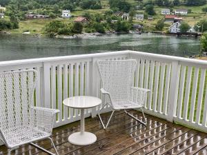 two chairs and a table on a deck with a river at 6 person holiday home in Bjoa-By Traum in Utbjoa