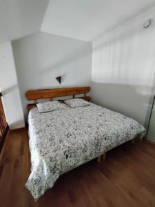 1 dormitorio con 1 cama con colcha de flores en Appartement 2/4 personnes en Bolquere Pyrenees 2000