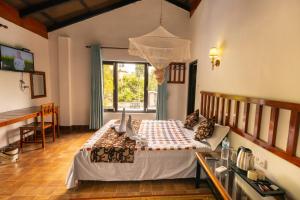 una camera con letto, tavolo e finestra di Hotel Parkside & Swimming Pool-Between Greenery and Azure ,Your Perfect Retreat a Chitwan