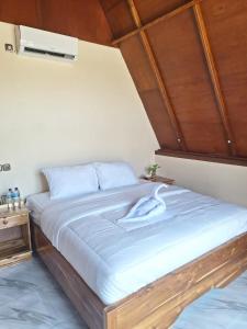 um quarto com uma cama grande e um tecto em madeira em D' Carasti Bungalow em Masbagik