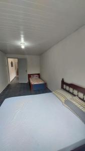 ein Schlafzimmer mit einem großen weißen Bett und einem Sofa in der Unterkunft Mares do Sul in São Vicente