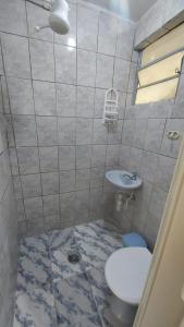 a bathroom with a toilet and a sink at Mares do Sul in São Vicente