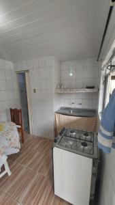 a kitchen with a stove in a small room at Mares do Sul in São Vicente +7 photos