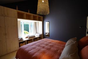 ein Schlafzimmer mit einem großen Bett und einem Fenster in der Unterkunft Gîte de la Côte Dor : logement zen à la campagne in Fosses-La-Ville