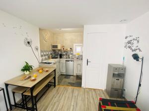 a kitchen with a wooden table and a table sidx sidx sidx at Studio centre village Soligny la Trappe proche Mortagne au perche -Sanateflo - in Soligny-la-Trappe