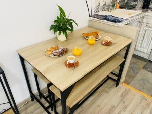 een tafel met eten en twee glazen sinaasappelsap bij Studio centre village Soligny la Trappe proche Mortagne au perche in Soligny-la-Trappe