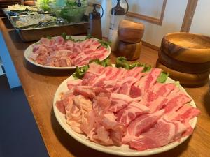 una mesa cubierta con platos de carne y ensalada en Starry Sky and Sea of Clouds Hotel Terrace Resort - Vacation STAY 51638v en Takeda