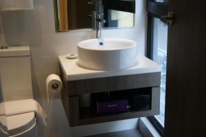 a bathroom with a sink and a toilet at Amrise Hotel Kitchener, Check In 9PM, Check Out 8AM in Singapore