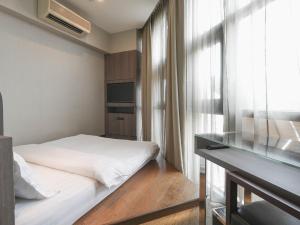 um quarto com uma cama, uma secretária e uma janela em Amrise Hotel Kitchener, Check In 9PM, Check Out 8AM em Singapura
