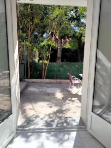 een open deur naar een patio met een stoel bij Appartement calme a 2 minutes a pieds du centre ville in Manosque
