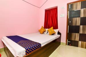 Habitación con cama con ventana y cortina roja en SPOT ON Hotel Vivek, en Hājīpur