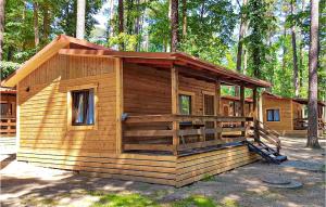 una pequeña cabaña de madera en el bosque con árboles en Nice Home In Ruciane - Nida, en Ruciane-Nida