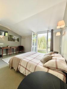 a bedroom with a large bed and a large window at Chambres Domaine de Laléard in Saint-Hilaire-de-Villefranche
