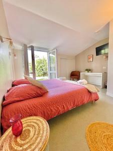 a bedroom with a large bed and a window at Chambres Domaine de Laléard in Saint-Hilaire-de-Villefranche