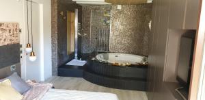 a bathroom with a tub with a bed and a television at Luxury Room & Private Spa - Rio Botteniga in Treviso +42 photos